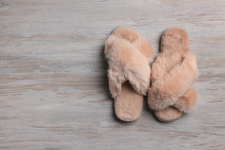 Pair of soft slippers on white wooden floor, top view. Space for textの写真素材