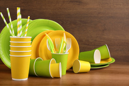 Set of bright disposable tableware on wooden tableの写真素材