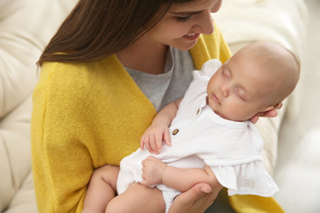 Mother with her sleeping baby on sofa, closeupの写真素材