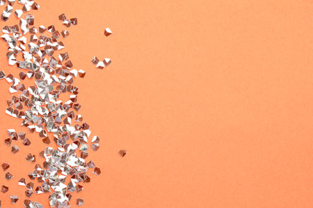 Pile of shiny glitter on pale pink background, flat lay. Space for textの写真素材