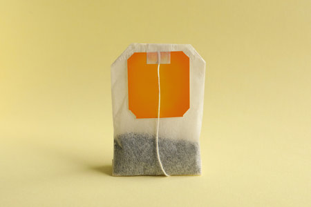 New tea bag with tab on yellow background, closeupの写真素材