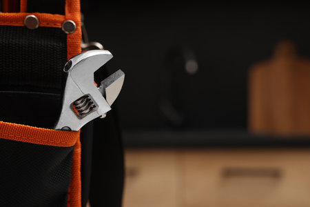 Plumber's tool bag with adjustable wrench indoors, closeup. Space for textの写真素材