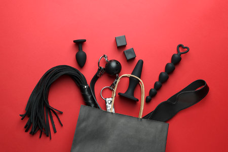 Shopping bag and different sex toys on red background, flat layの写真素材