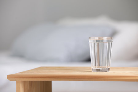 Glass of pure water on wooden table indoors. Space for textの写真素材