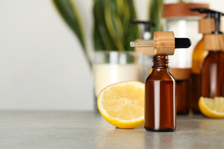 Bottle of #essential oil, pipette and lemon on light gray table, space for textの写真素材