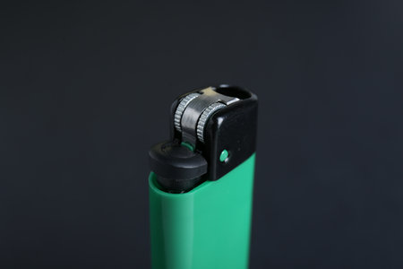 Stylish small pocket lighter on black background, closeup