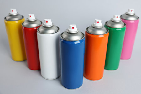 Colorful cans of spray paints on light gray backgroundの写真素材