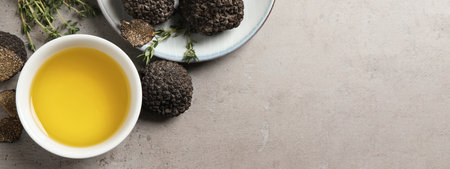 Fresh truffles, oil in bowl and thyme on light gray table, flat lay with space for text. banner designの写真素材