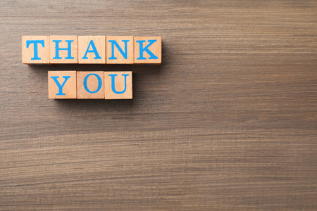 Phrase Thank You made of cubes with letters on wooden table, flat lay. Space for textの写真素材