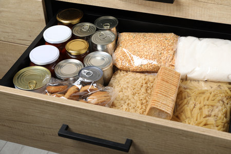 Open drawer with different products, closeup. food donation