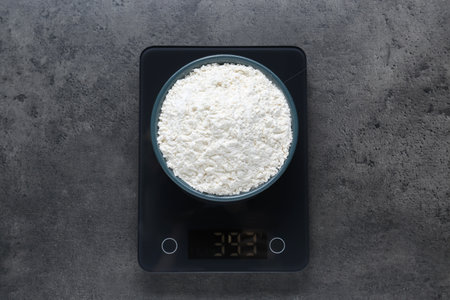 Electronic scales with flour on gray table, top viewの写真素材