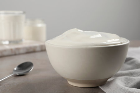 Bowl with delicious organic yogurt on gray table, closeupの写真素材