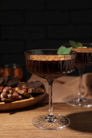 Dessert bowls of delicious hot chocolate and ingredients on wooden table, closeupの写真素材