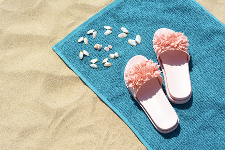 Towel, seashells and flip flops on sand, above view with space for text. beach accessoriesの写真素材