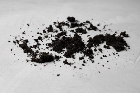 Scattered coffee grounds on light surface, closeupの写真素材