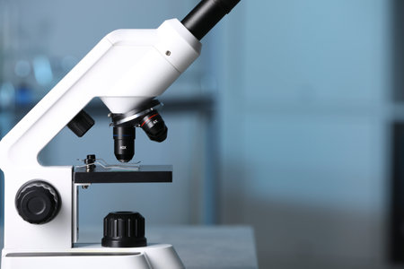 Modern medical microscope against blurred background, closeup. Space for text