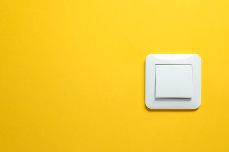 Modern plastic light switch on orange background. Space for textの写真素材