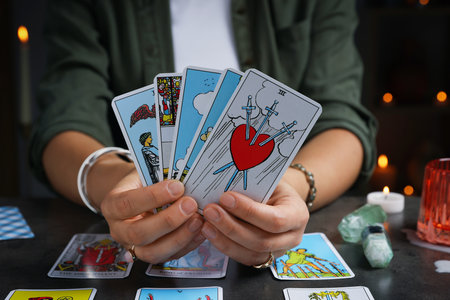 Fortune teller with tarot cards at gray table indoors, closeupの写真素材