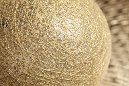 Texture of sphere made with golden threads, closeup