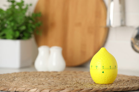 Kitchen timer in shape of lemon on wicker mat indoors. Space for textの写真素材
