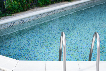 Ladder with grab bars in outdoor swimming poolの写真素材