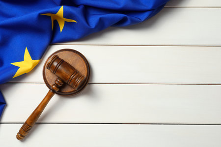 Judge's gavel and flag of European Union on white wooden table, flat lay. Space for textの写真素材