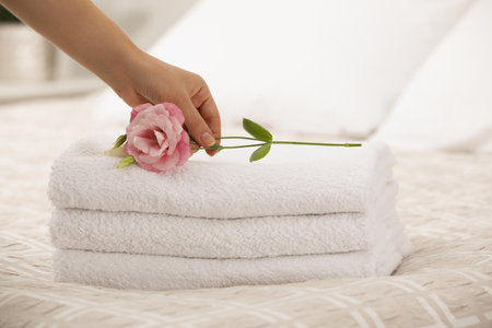 Woman Eustoma flower on putting towels in bedroom, closeupの写真素材