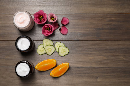 Flat lay composition with jars of face cream on wooden table, space for textの写真素材