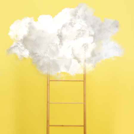 Wooden ladder leading to white cloud on yellow background. Concept of growth and development