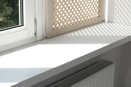 Empty white window sill and decorative wooden shutter indoors