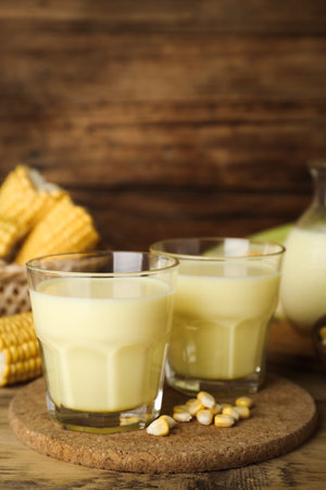 Tasty fresh corn milk in glasses on wooden tableの写真素材