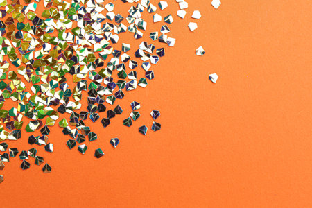 Shiny bright glitter on coral background, flat lay. Space for textの写真素材