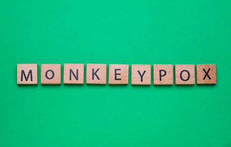 Word Monkeypox made of wooden squares on green background, top viewの写真素材