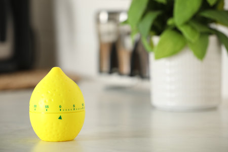 Kitchen timer in shape of lemon on white table indoors. Space for textの写真素材