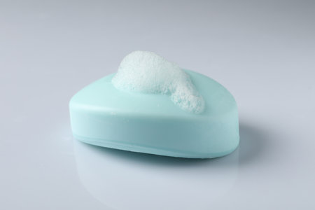 Soap with fluffy foam on white background