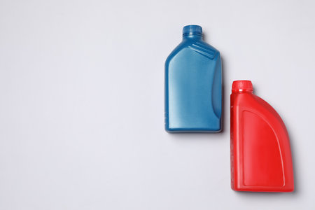 Motor oil in different canisters on light background, flat lay. Space for textの写真素材