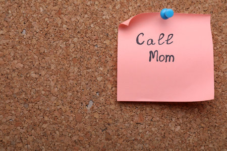 Paper note with words Call Mom pinned on cork board, space for textの写真素材