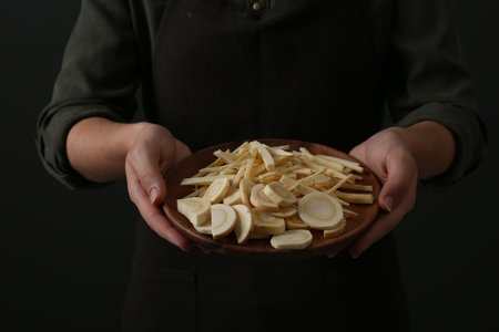 Woman holding plate with cut parsnips, closeupの写真素材