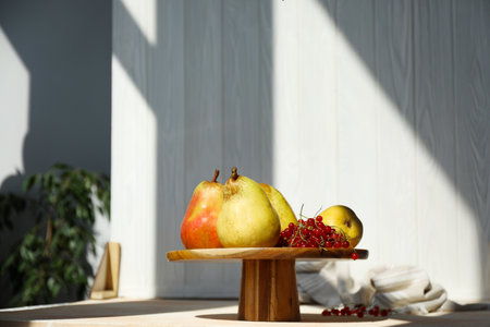 Stand with juicy pears, red currants and double-sided backdrop in photo studioの写真素材