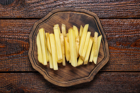 Cut raw potatoes on wooden table, top viewの写真素材