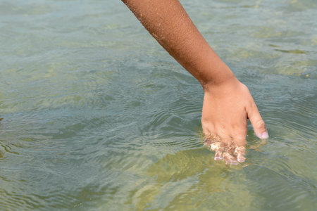 Kid touching cool clear water outdoors, closeupの写真素材