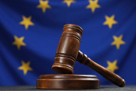 Wooden judge's gavel on black table against flag of European Union, closeupの写真素材