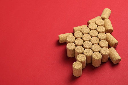 Christmas tree made of wine corks on red background. Space for textの写真素材