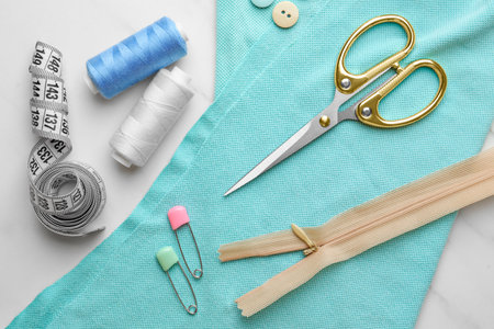 Threads and other sewing supplies on white marble table, flat layの写真素材