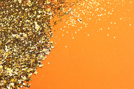 Shiny bright golden glitter on pale coral background. Space for textの写真素材