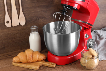 Modern red stand mixer, croissant and cookies on wooden tableの写真素材