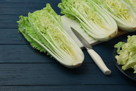 Cut fresh ripe Chinese cabbages on blue wooden tableの写真素材