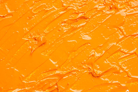 Beautiful strokes of orange oil paint as background, closeupの写真素材