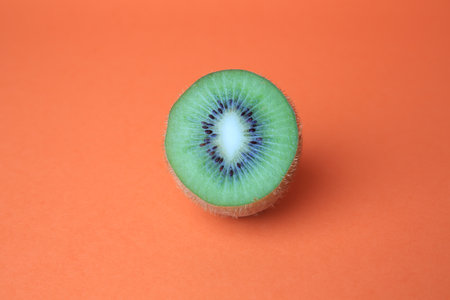 Cut fresh ripe kiwi on orange backgroundの写真素材