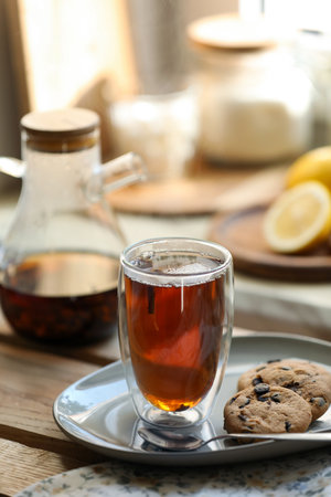Glass of delicious tea and cookies on wooden tableの写真素材